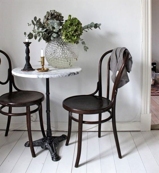 Cocina con mesa redonda de mármol francés y sillas de madera curvada